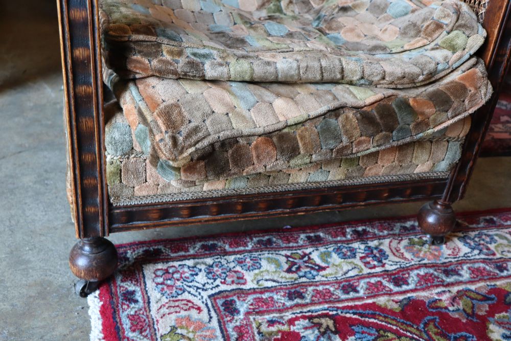 A pair of early 20th century oak bergere armchairs